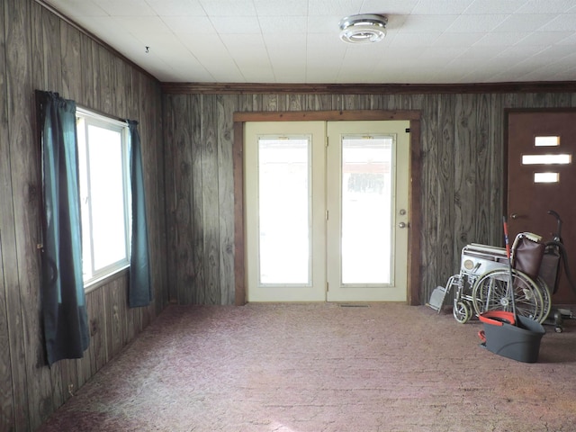 misc room with ornamental molding, wooden walls, and carpet floors