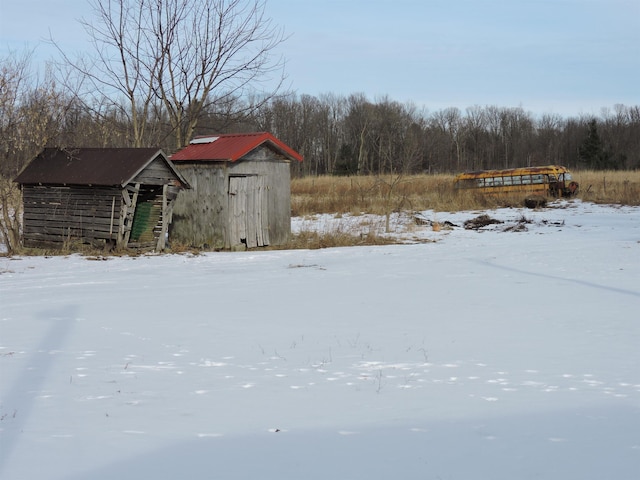 snowy yard with a storage shed