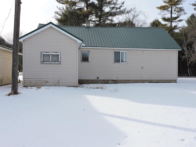 view of snow covered back of property