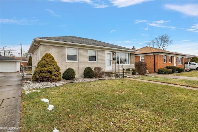 single story home with an outbuilding, a garage, and a front lawn