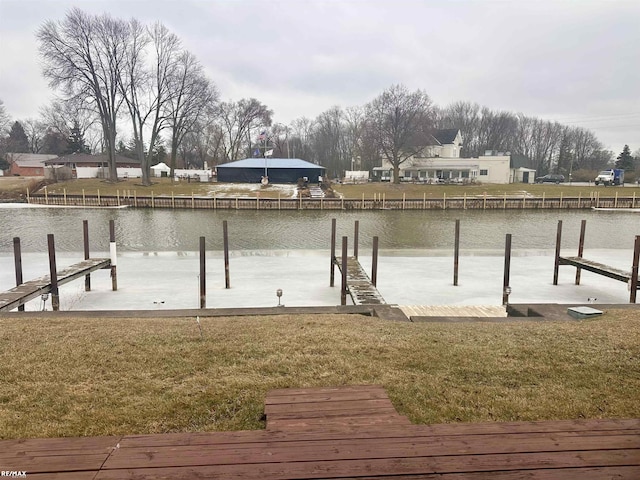 dock area with a water view and a yard