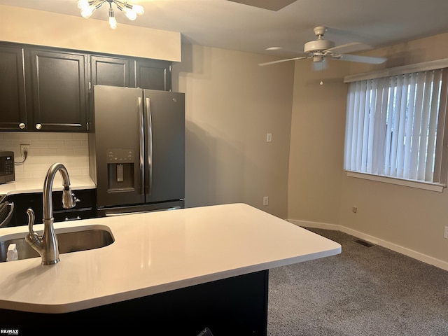 kitchen with appliances with stainless steel finishes, tasteful backsplash, sink, carpet, and ceiling fan