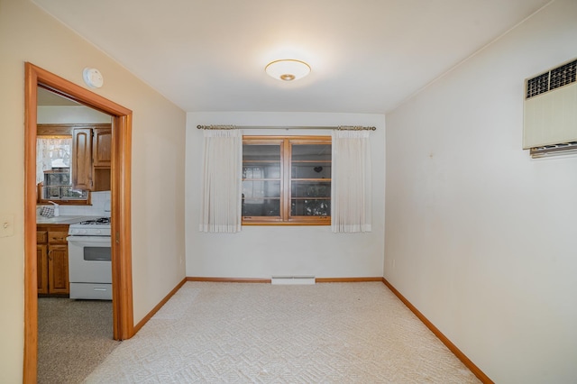 spare room with a baseboard heating unit, a wall mounted air conditioner, and light colored carpet