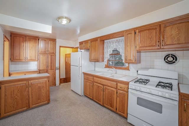 kitchen with tasteful backsplash, white appliances, and sink