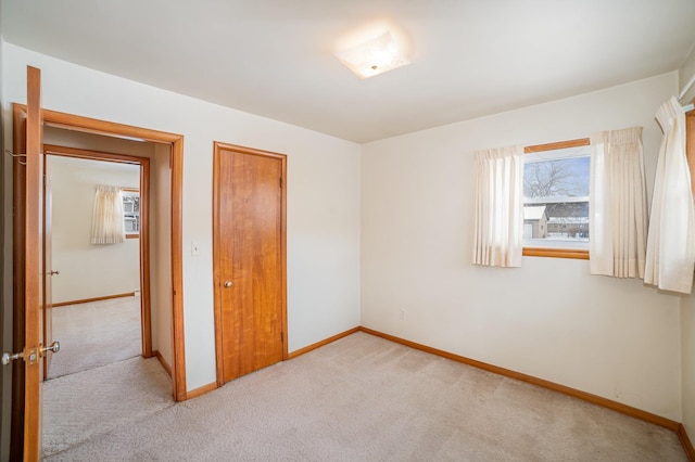 unfurnished bedroom featuring light colored carpet and a closet