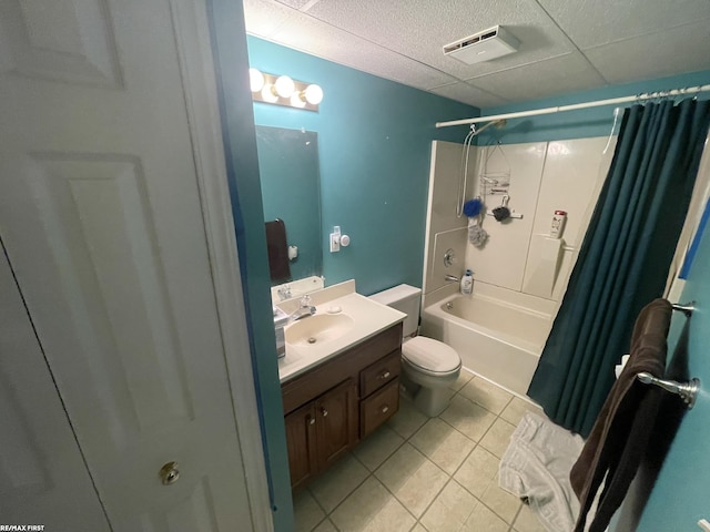 full bathroom featuring tile patterned flooring, vanity, toilet, shower / bathtub combination with curtain, and a drop ceiling