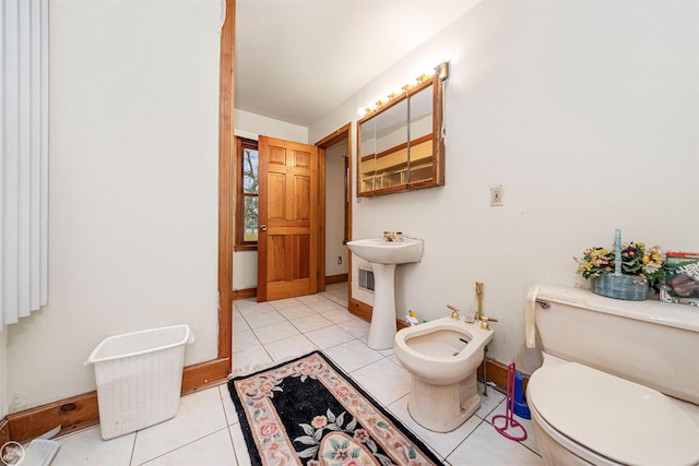 bathroom featuring a bidet, sink, toilet, and tile patterned flooring