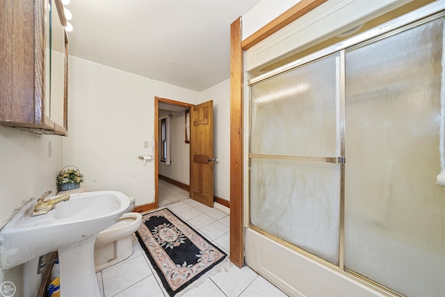 bathroom with tile patterned floors, enclosed tub / shower combo, and toilet