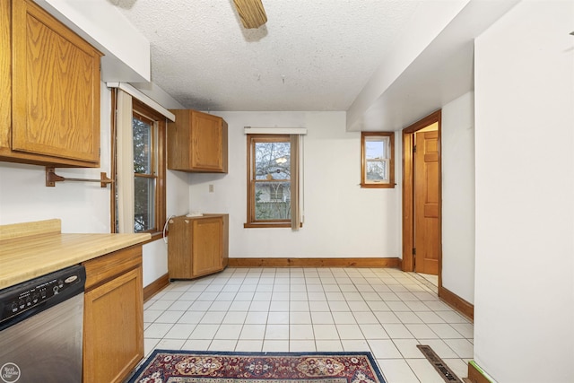 kitchen featuring dishwasher, light tile patterned floors, ceiling fan, and a textured ceiling