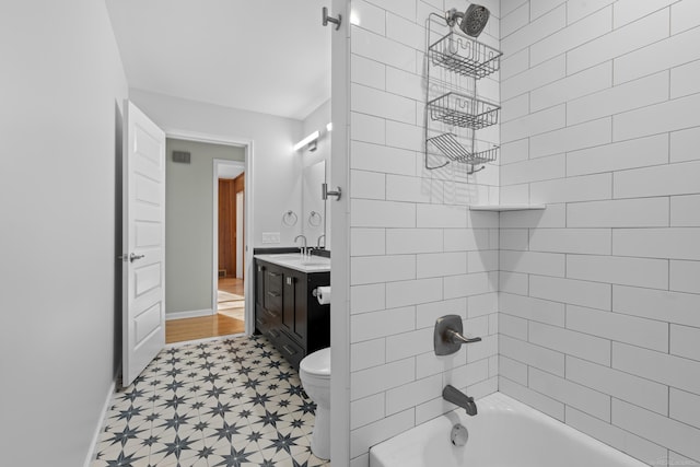 full bathroom featuring vanity, tiled shower / bath combo, and toilet