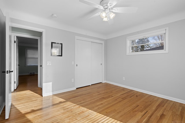 unfurnished bedroom featuring wood-type flooring, ceiling fan, and a closet