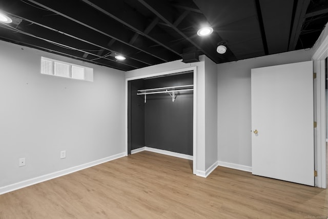 unfurnished bedroom featuring light hardwood / wood-style flooring and a closet