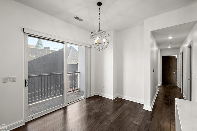 unfurnished dining area featuring an inviting chandelier and dark hardwood / wood-style flooring