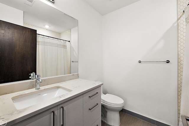 bathroom featuring vanity, toilet, and walk in shower