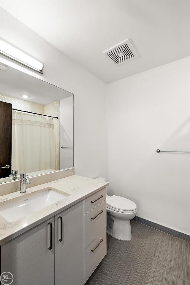 bathroom featuring vanity, toilet, and a shower with shower curtain