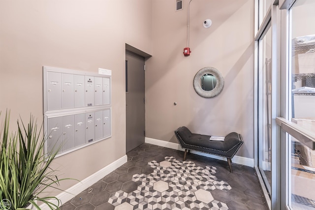 living area featuring a towering ceiling and mail boxes