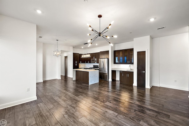 kitchen featuring a chandelier, hanging light fixtures, dark hardwood / wood-style flooring, a kitchen island, and stainless steel appliances