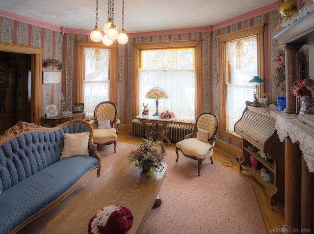 living area with hardwood / wood-style floors, radiator, and a wealth of natural light