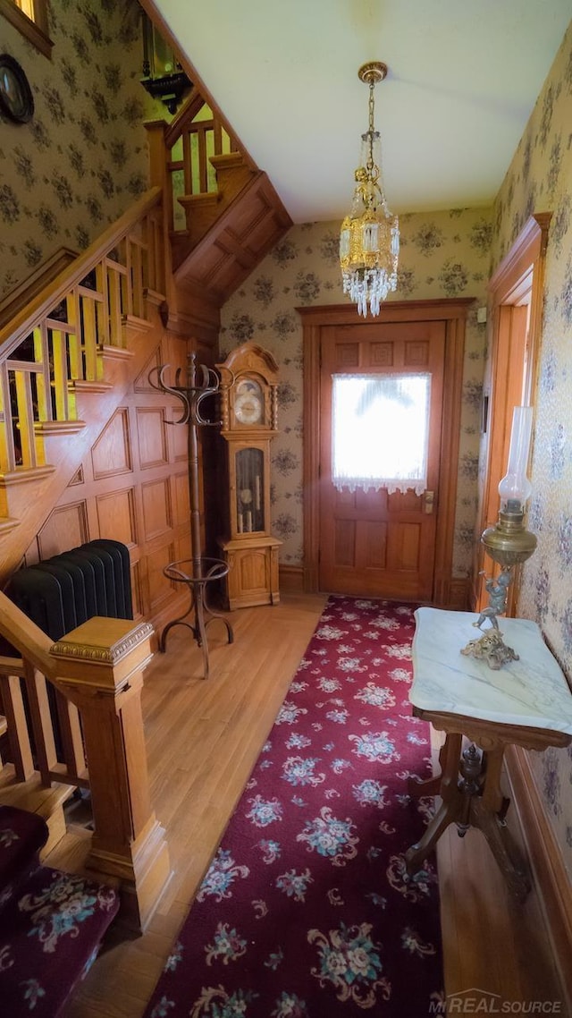 foyer featuring wood-type flooring, vaulted ceiling, and a chandelier