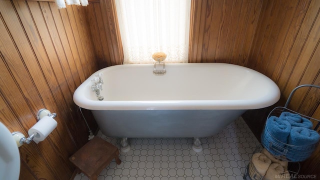 bathroom with a tub to relax in and wood walls