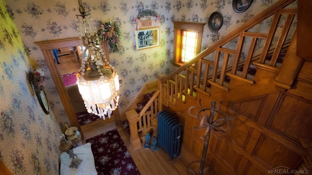 staircase with radiator heating unit and wood-type flooring