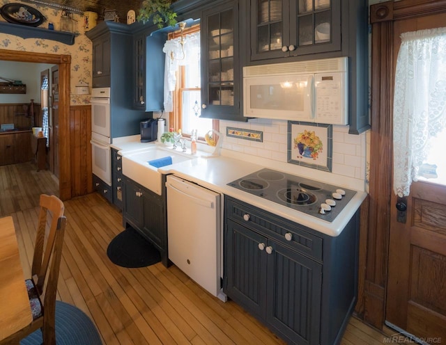 kitchen featuring sink, white appliances, and light hardwood / wood-style flooring