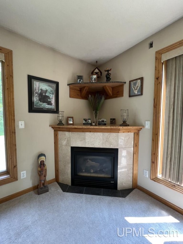 interior details featuring carpet flooring and a tile fireplace