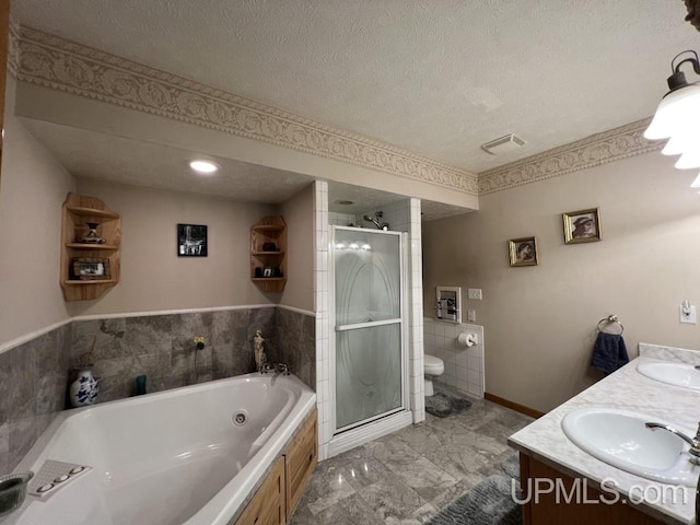 full bathroom with vanity, toilet, independent shower and bath, and a textured ceiling