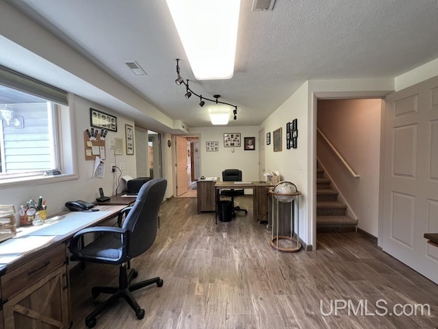 office featuring rail lighting, dark hardwood / wood-style floors, and a textured ceiling