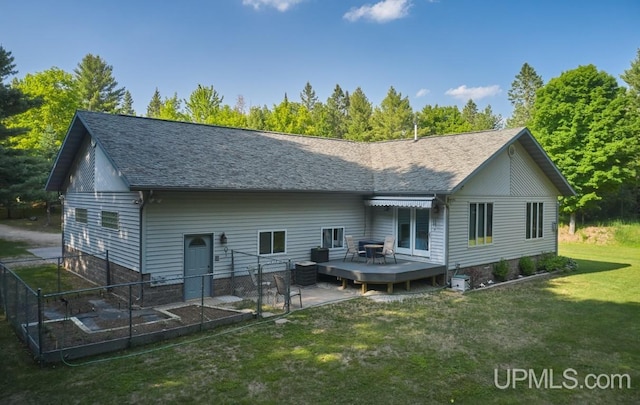 rear view of property featuring central AC unit, a lawn, and a deck