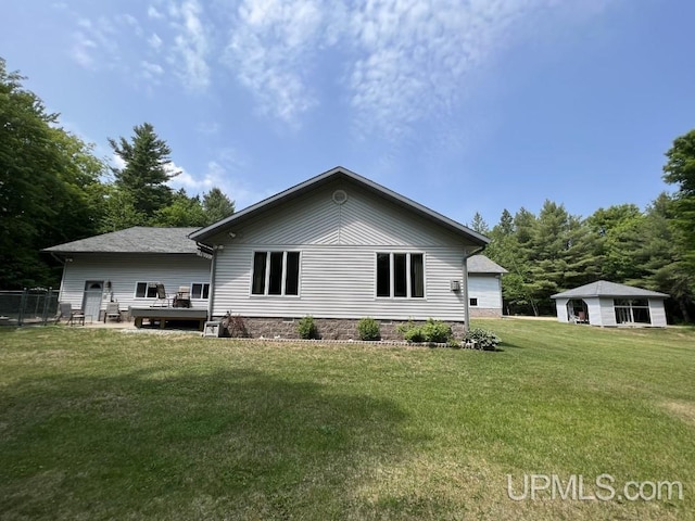 rear view of house featuring a wooden deck and a yard