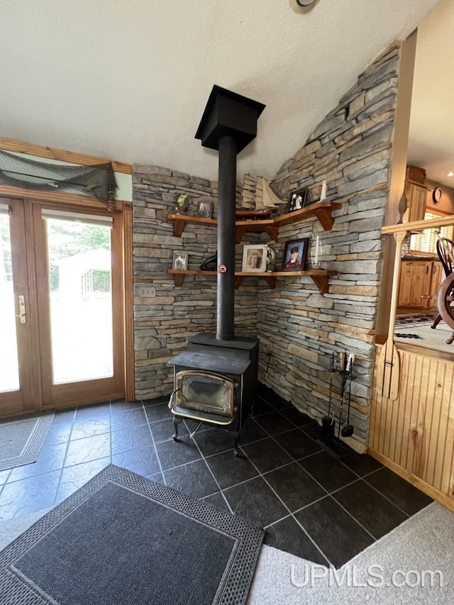 details with a textured ceiling and a wood stove