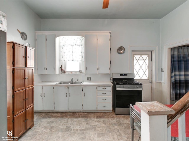 kitchen with white cabinets, a wealth of natural light, sink, and stainless steel gas range oven