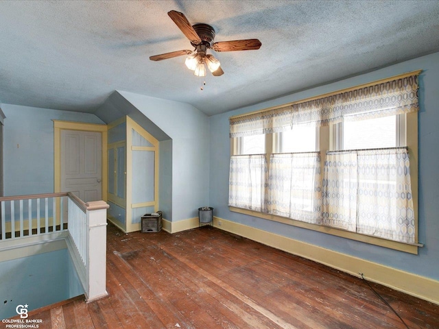 bonus room featuring lofted ceiling, ceiling fan, dark hardwood / wood-style floors, and a textured ceiling