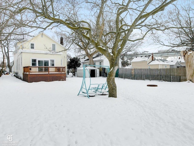 yard layered in snow with a wooden deck