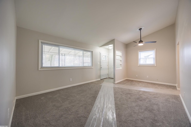 empty room featuring ceiling fan, vaulted ceiling, and carpet