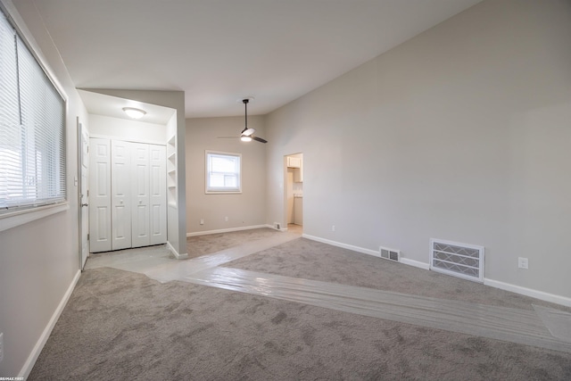 spare room with lofted ceiling, light colored carpet, and ceiling fan