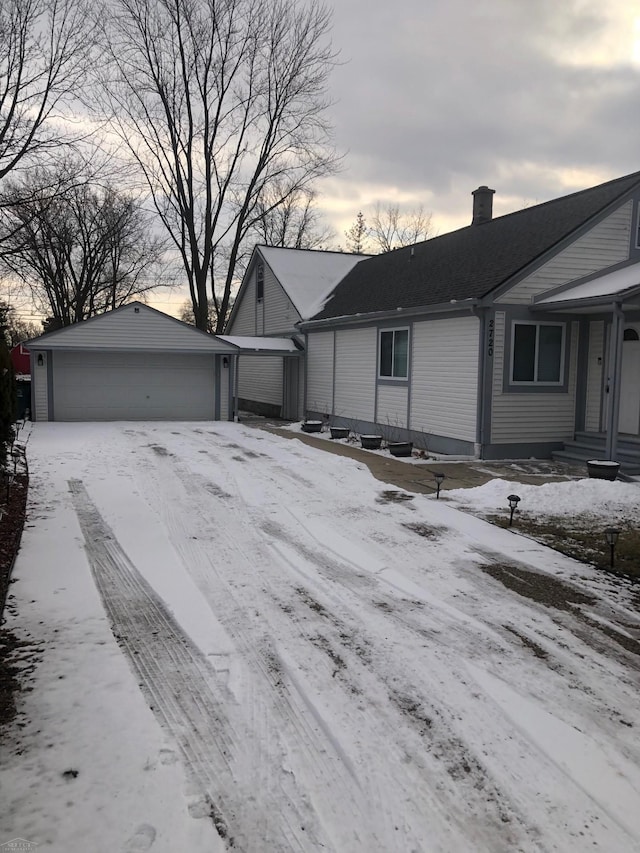 view of front facade featuring a garage, an outbuilding, and a chimney