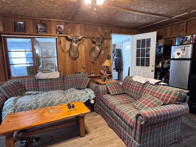 living room with hardwood / wood-style flooring and wooden walls