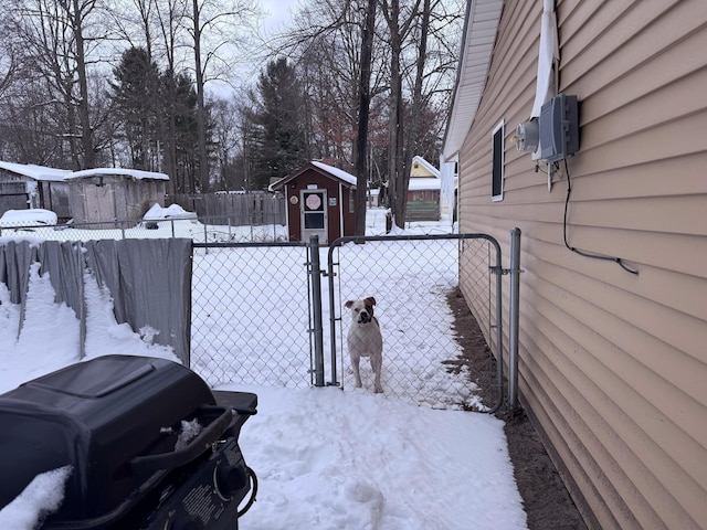 yard covered in snow featuring a storage shed