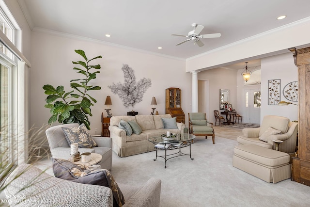 living room with light colored carpet, a healthy amount of sunlight, decorative columns, and ornamental molding