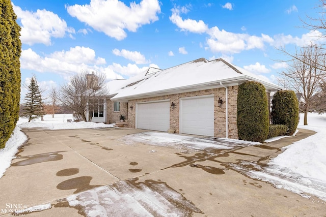 snow covered property with a garage