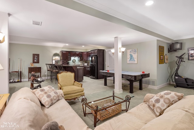 carpeted living room with a notable chandelier and crown molding