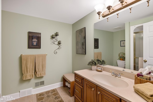 bathroom featuring tile patterned flooring, walk in shower, vanity, and toilet