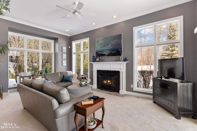 carpeted living room featuring ceiling fan and ornamental molding