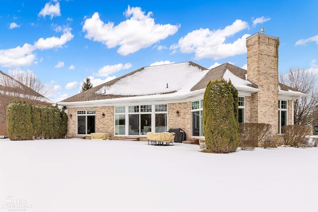 view of snow covered back of property