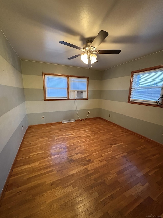 unfurnished room featuring wood-type flooring, cooling unit, and ceiling fan