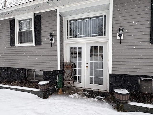 snow covered property entrance with french doors