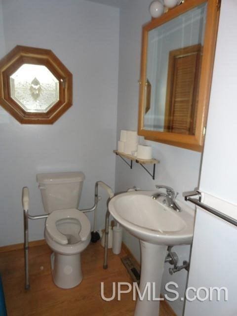 bathroom with hardwood / wood-style floors and toilet