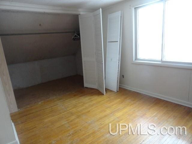 unfurnished bedroom featuring baseboards and wood finished floors